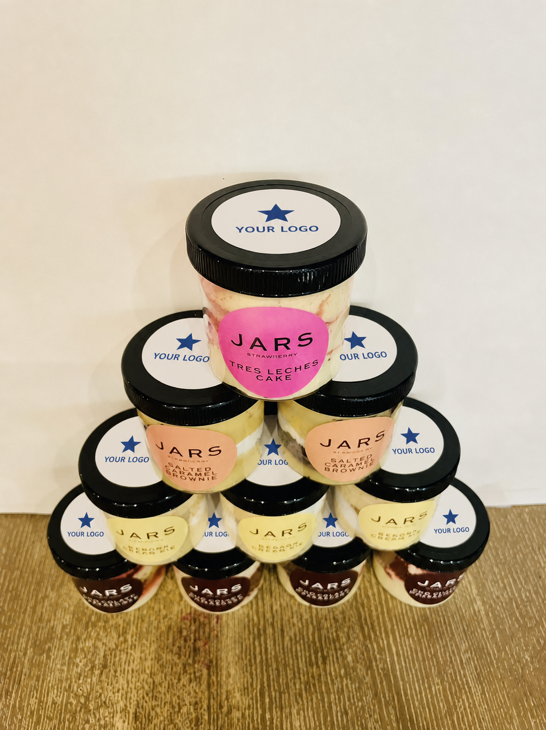 A pyramid of individually lidded JARS with example custom logo stickers